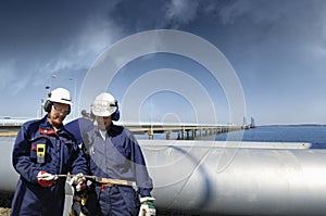 Oil workers with giant main pipeline