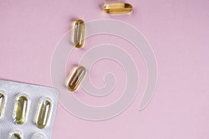 Oil yellow capsules on pink background