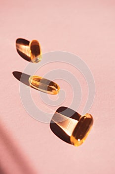 Oil yellow capsules on pink background