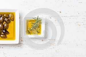 Oilive oil with olives and herbs on white background photo