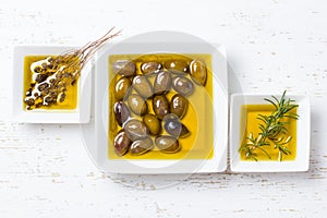 Oilive oil with olives and herbs on white background photo