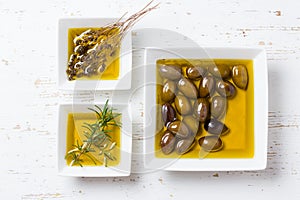 Oilive oil with olives and herbs on white background photo