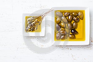 Oilive oil with olives and herbs on white background photo