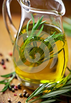 Oilive oil with rosemary in a glass jug photo