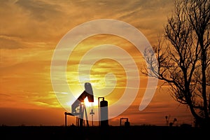 Oilwell Pump Silhouette with a colorful Sunset and tree`s in Kansas.