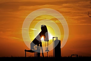 Oilwell Pump Silhouette with a colorful Sunset and tree`s in Kansas.