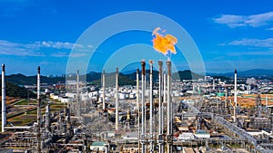 Oilâ€‹ refineryâ€‹ andâ€‹ petrochemicalâ€‹ plant industrial working with fire and blue sky background, Aerial view oil and gas