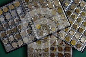 Ð¡oins of different countries are arranged in transparent blisters. Page from album full with old coins. Coin storage method.