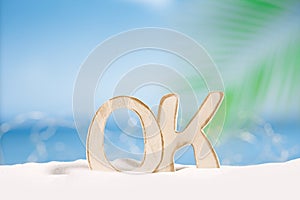 OK word wooden letters with ocean , beach and seascape