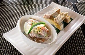 Oka - known as kokoda, poke, ceviche, or poisson cru - is Polynesian raw fish salad from Samoa, with taro chips photo