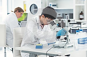 Okay lets adjust that a little closer...an attractive young female scientist looking through a microscope in a