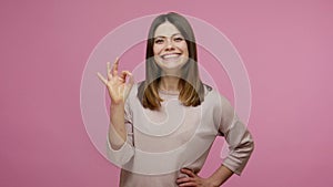 Okay, well done! Lovely happy satisfied brunette woman smiling broadly, laughing and showing ok finger sign