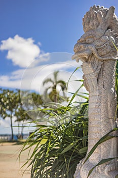 Okinawan Ryukyu dragon stone sculpture on the sunset beach in the American Village neighborhood of Chatan City in Okinawa