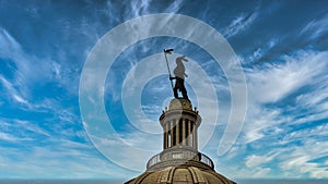 Oklahoma state capitol statue atop the dome against a blue sky