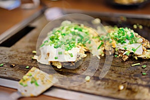 Okonomiyaki in teppanyaki pan at restaurant.  Japan food concept