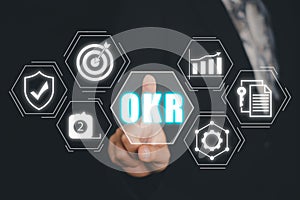 OKR, Objectives and Key Results concept, Business person hand touching Objectives and Key Results icon on virtual screen, Methods