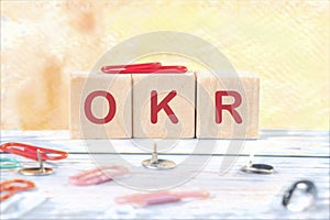 OKR . Objectives and Key Results OKR conceptit is written on wooden cubes on a colored background