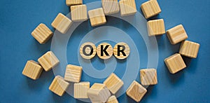 OKR, objectives and key results symbol. Concept words `OKR, objectives and key results` on circles on a beautiful blue backgroun