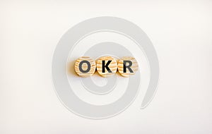OKR, objectives and key results symbol. Concept words OKR objectives and key results on wooden circles on a beautiful white