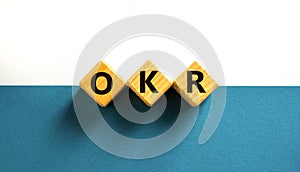 OKR, objectives and key results symbol. Concept words OKR objectives and key results on wooden cubes on a beautiful white