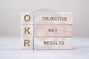 OKR text Objectives, Key and Results wooden cube blocks on table background. business target and focus concepts