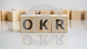 OKR word is made of wooden building blocks lying on the gray table, concept