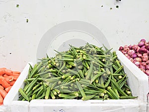 Okra, onions and carrots on a market stall