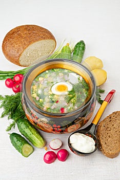 Okroshka summer cold yogurt soup in a wooden bowl. Radish, eggs, cucumber, green onions, dill. Top view. Khokhloma-style wooden