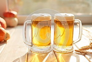 Oktoberfest beer. Glass beer mugs full of golden lager with thick frothy heads conceptual of Oktoberfest. Beer mug. Big glass of