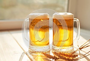 Oktoberfest beer. Glass beer mugs full of golden lager with thick frothy heads conceptual of Oktoberfest. Beer mug. Big glass of
