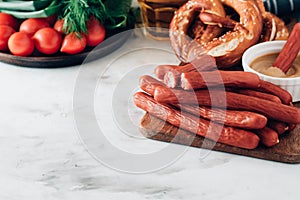 Oktoberfest food, appetizing beer snacks set for big company.Grilled sausages, chips, pretzel,crackers on white table.Toned image.