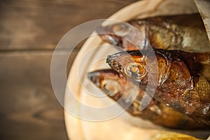 Oktoberfest holiday concept. Beer, smoked fish, chips on a wooden textural background in a dark key. Beer in a glass, fish in pape