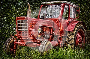 Old abandon red traktor in nature.