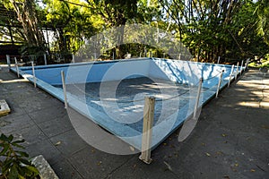 Old abandoned blue pool in the backyard. Dry unused swimming pool. autumn