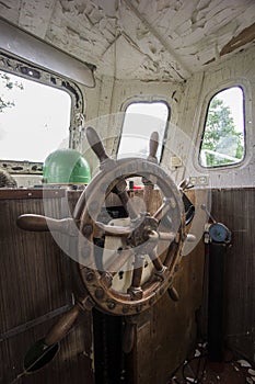 Old abandoned boat, steering wheel from brass and wood. Ship rudder. Sailboat helm