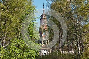 Old abandoned brick bell tower seen through the trees