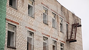 Old abandoned brick building used for housing and rental apartments or hospital. Clip. Broken windows of a ruined house