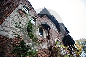 Old abandoned brick mystic mansion. Gothic building at autumn