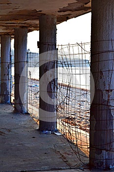Old abandoned building on the beach. Weathered columns next to blue sea