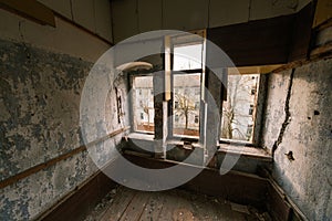 Old abandoned building room with wooden floor and window in daylight