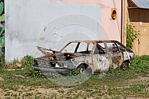 Old abandoned burned car parked in the courtyard