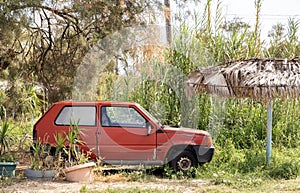 Old abandoned car in overgrown garden