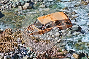 Old and abandoned car in the river
