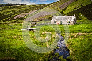 Old abandoned cottage by a rippling stream in Scotland