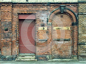 Old abandoned derelict industrial premises with bricked up door