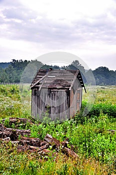 Old abandoned destroyed a barn in a green field