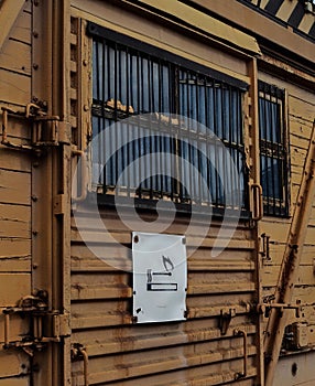 Old abandoned door of a train wagon with a flammable icon with metal window