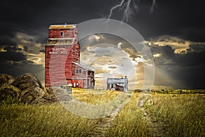 Old abandoned elevator under a dark stormy sky with lightening.