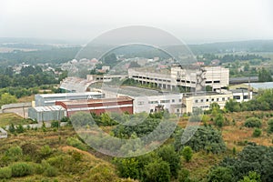 old abandoned factory building in the middle of a green forest. Panorama of the city with a view of factories and enterprises.