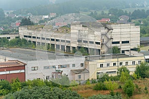 old abandoned factory building in the middle of a green forest. Panorama of the city with a view of factories and enterprises.